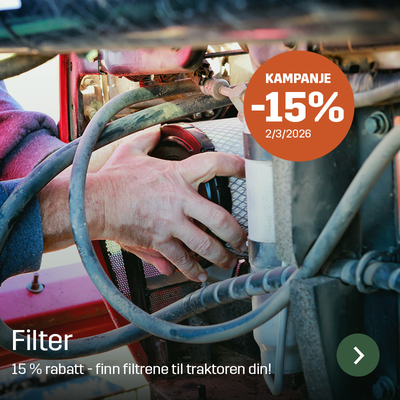 En hånd monterer et sylindrisk filter i motorrommet på en traktor, omgitt av slanger og metallkomponenter. Sagros filter brukes ved service og vedlikehold for å sikre ren luft eller drivstoff i landbruksmaskiner.